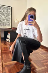 Pantalón Oxford negro de cuero sintético con cierre frontal y aberturas laterales con pasamanería plateada.