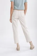 Pantalón de jean color crudo, corte recto, con apliques de gamuza en color beige en la parte inferior de las piernas.