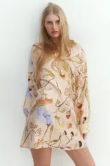 Vestido corto de viscosa con estampado floral, cuello mao fruncido y abertura en V. Tiene corte holgado, cinturón extraíble para atar en la cintura, mangas globo largas de corte raglán con abertura y botón en los puños.