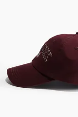 Gorra de béisbol color borgoña con bordado frontal de la leyenda "New York 1996" en color blanco.