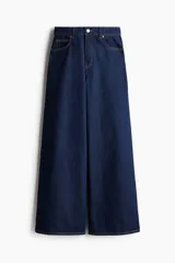 Pantalón de jean azul oscuro de tiro alto, corte recto y pierna ancha. Diseño de cinco bolsillos con costuras a la vista. Inspirado en los años 70.