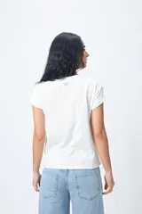 Remera color beige de manga corta con cuello redondo y estampado con ilustración gráfica al frente y frase retro.