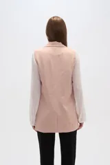 Chaleco blanco sin mangas con solapas, confeccionado en lino y viscosa. De corte recto y calce al cuerpo.