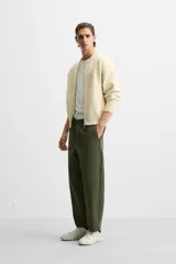 Pantalón de hombre color beige, corte carrot fit, con cintura elástica ajustable con cordón, bolsillos frontales y bolsillo trasero de plastrón.