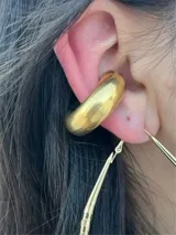 Aros tipo cuff plateados, gruesos y de diseño moderno.