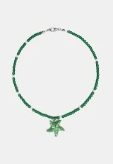 Collar de cuentas de vidrio verdes con detalles de perlas blancas y un dije central en forma de estrella de mar verde con puntos blancos. Incluye una cadena de extensión para ajustar el largo.