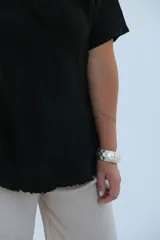 Remera negra de corte holgado con cuello en V y mangas cortas.