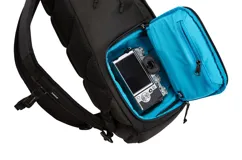 Mochila Thule EnRoute de 20 litros, color negro con detalles en gris. Cuenta con compartimento acolchado para cámara DSLR o mirrorless, bolsillo interior para tablet o laptop de hasta 13 pulgadas, bolsillo lateral para botella de agua o trípode, compartimento superior con tela suave para celular y objetos de valor, bolsillo frontal de acceso rápido y pasador para sujetar a valija con ruedas.