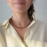 Gargantilla de cuentas facetadas color borgoña con cierre de mosquetón dorado y cadena de alargue. Incluye cuatro dijes colgantes dorados: cerezas con strass rosa, frutilla roja, corazón rojo esmaltado y estrella con strass.