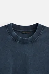 Camiseta azul con efecto lavado, corte holgado, cuello redondo y mangas cortas.