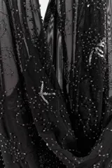 Top halter de tul color gris claro, con escote fluido drapeado y espalda descubierta. Presenta bordados con aplicación de abalorios en tonos oscuros y dorados.