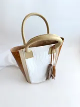 Matera blanca y marrón de 31 cm de altura, hecha 100% en cuero, sin división interna y con asas de cuero.