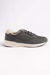 Zapatillas deportivas grises con cordones blancos y suela color crema.