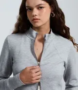 Saco negro de modal con recortes modernos y cierre delantero por cremallera. Tiene cuello alto y mangas largas.