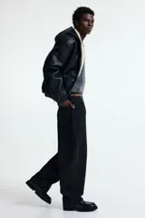 Pantalón de jean negro de corte holgado, con tiro bajo y cinco bolsillos.