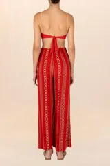 Pantalón de corte recto color rojo con estampado de cadenas doradas, pretina elástica, cierre y broche al frente, pinzas y bolsillos laterales.