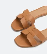 Sandalias planas color crema con puntera cuadrada y tiras anchas en forma de H.