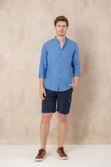 Camisa celeste de lino con cuello mao, corte slim fit, manga larga con puños abotonados y cierre frontal con botones.