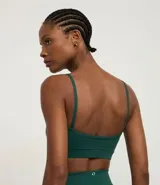 Top deportivo negro de microfibra, con breteles finos y detalle fruncido en el busto.