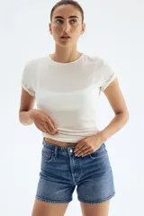 Short de jean azul de tiro alto, con cinco bolsillos y ruedo desflecado.