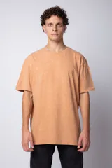 Remera color durazno con efecto gastado, de corte holgado y mangas cortas.