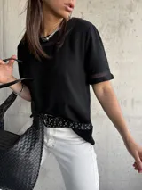 Remera negra de mangas cortas con detalle de encaje en cuello y mangas.