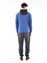 Campera deportiva azul con paneles negros en la parte superior y capucha. Cierre frontal con cremallera.