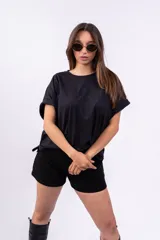 Remerón negro de corte holgado con cuello redondo y mangas cortas con dobladillo.