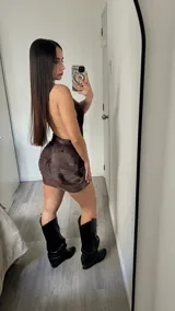 Vestido corto marrón con estampado difuminado, escote halter pronunciado y espalda descubierta.