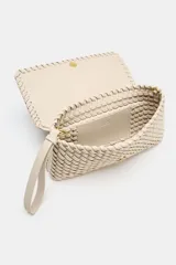 Bolso alargado color beige con diseño trenzado, asa bandolera y tirador con pulsera de mano. Incluye bolsillo interior y cierre mediante solapa y botón imantado.