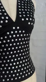 Top negro con lunares plateados, escote halter y espalda descubierta.