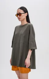 Remera de manga corta color verde militar, con calce extra oversize y un recorte horizontal que atraviesa el pecho y la espalda.