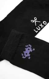 Medias negras con diseño de un monstruo de videojuego pixelado en color lila.