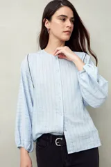 Camisa blanca a rayas grises, de lino, con cuello mao, mangas largas abullonadas y bordados en las sisas.