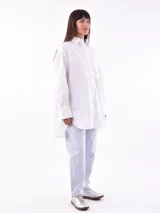 Camisa blanca oversize de manga larga con cuello clásico y bolsillo en el pecho.