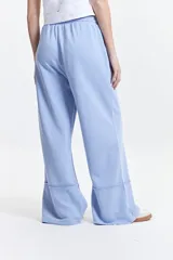 Pantalón de felpa celeste con cintura elastizada ajustable y bolsillos laterales.