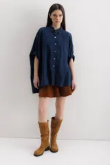 Camisa azul de mangas cortas abullonadas, con cuello clásico y cierre frontal con botones.