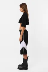 Remera corta negra de calce oversize confeccionada en jersey de algodón. Cuello de ribb ancho, ruedo al corte y estampa en la manga derecha.