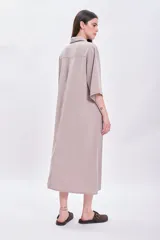Vestido largo color visón con cuello solapado, manga corta y corte holgado.