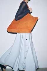 Bolso tipo maxi shopper color marrón de ante, con doble asa de hombro y bolsillo interior con cremallera.