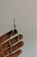 Collar hecho a mano en bronce, con diseño de dije único y cordón ajustable.