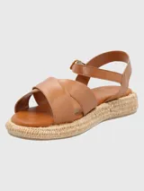 Sandalias Concetta de cuero color marrón claro, con tiras cruzadas y ajuste con hebilla en el tobillo. Plataforma con base tejida tipo esparto y plantilla acolchada.