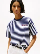 Remera de algodón a rayas horizontales azules y blancas, con cuello redondo azul y logo de Tommy Hilfiger en el pecho.
