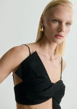 Top negro con tirantes finos, diseño crop y lazo en el frente.