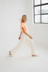 Pantalón blanco de corte palazzo, con lazo en la cintura y tajos laterales.