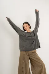 Buzo verde militar de tejido liviano con acabado gastado, corte oversize, cuello bote y mangas largas con hombro caído.