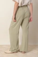 Pantalón ancho color beige de lino y rayón, con cintura elastizada ajustable con cordón y bolsillos laterales.