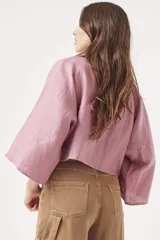 Camisa color lila de lino con corte cropped, mangas 3/4 amplias y cierre frontal con botones.