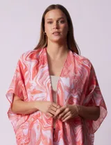 Kimono tejido con estampado abstracto en tonos grises y blancos, con mangas cortas y terminación de ruedo con borlas negras.