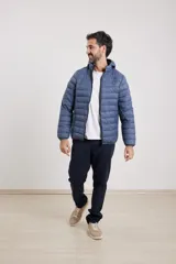 Campera capitoneada color bordó con capucha desmontable con cierre, dos bolsillos exteriores con cierre y un bolsillo interior.